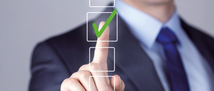 Mann legt Zeigefinger auf ein transparentes Quadrat mit einem grünen Häckchen.