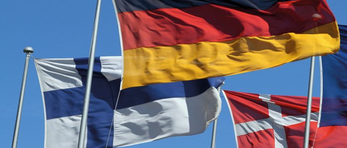 The picture shows the flags of Denmark, Finland, and Germany flying in the wind