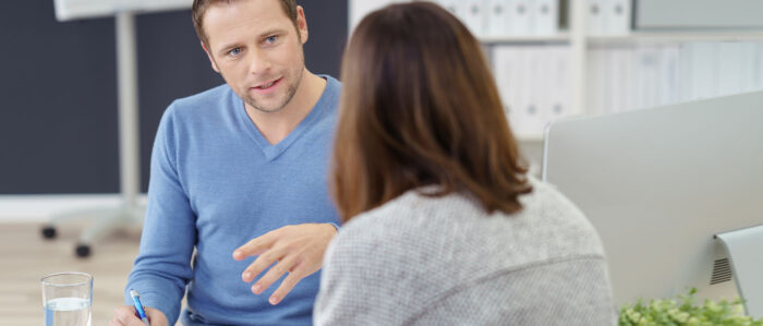 Mann führt ein Beratungsgespräch mit einer Frau.