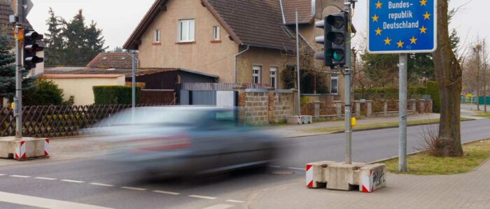Auto mit fährt hoher Geschwindigkeit über einen Grenzübergang in die Bundesrepublik Deutschland.