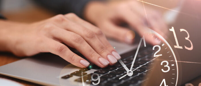 Die Nahaufnahme von weiblichen Händen, die auf der Tastatur eines Laptops tippen wird überblendet von dem Zifferblatt einer Uhr und einem Kalenderblatt.