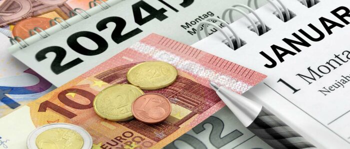 Das Bild zeigt einen Kaldender aus dem Jahr 2024 und einen 10-Euroschein sowie Centmünzen welche auf dem Kalender liegen.