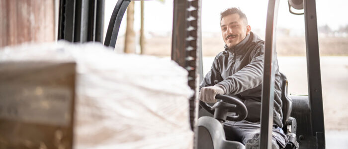 Lächelnder Gabelstaplerfahrer bei der Arbeit