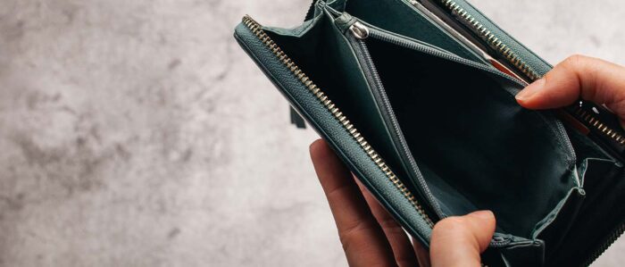 Person hält einen leeren Geldbeutel in der Hand.