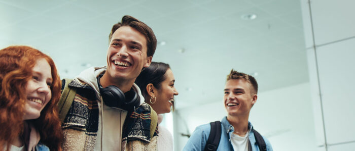 Jugendliche laufend lachend im Schulgebäude.