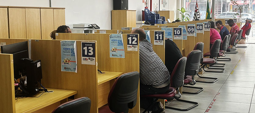 Eine Reihe mit Plätzen in einem brasilianischen Jobcenter, an denen Bewerbungsgespräche stattfinden. Zwischen den Plätzen befindet sich nur ein Sichtschutz.